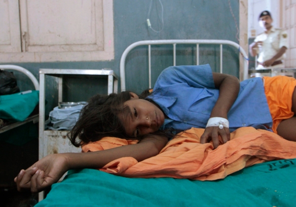 A sick girl rests at a hospital after consuming contaminated school meals in the eastern Indian city of Patna