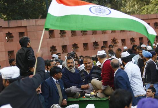 A supporter of Aam Aadmi (Common Man) Party (AAP) flutters India's national flag as Delhi's chief minister Arvind Kejriwal takes part in a protest in New Delhi J
